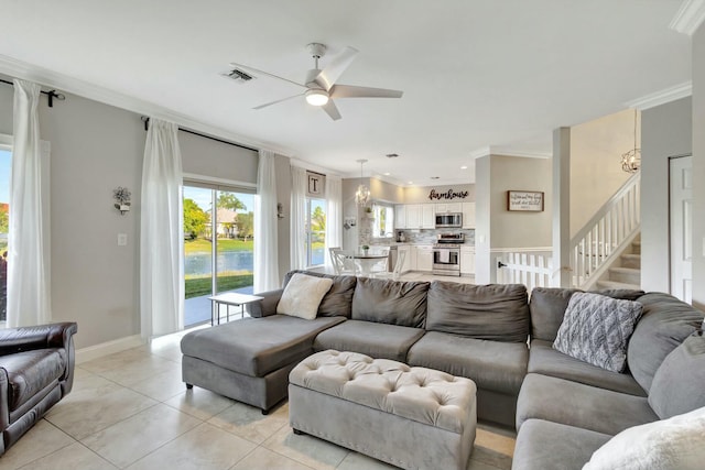 living room with ceiling fan with notable chandelier, ornamental molding, and light tile patterned floors