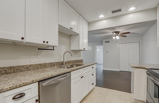 kitchen featuring appliances with stainless steel finishes, sink, white cabinets, and light stone counters