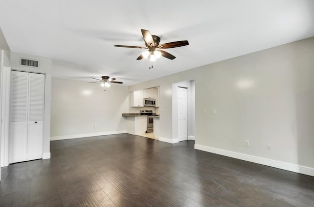 unfurnished living room featuring dark wood-type flooring and ceiling fan