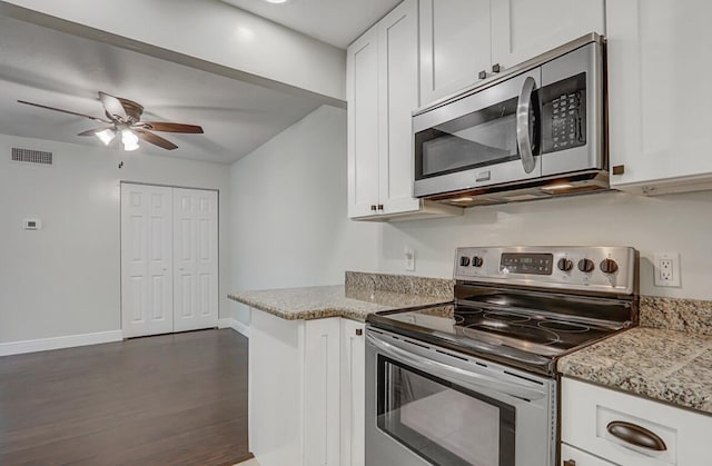 kitchen with white cabinetry, appliances with stainless steel finishes, dark hardwood / wood-style floors, and light stone counters