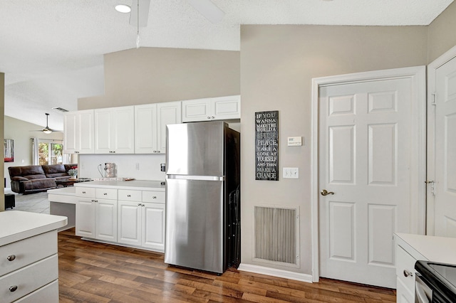 kitchen with stainless steel refrigerator, lofted ceiling, white cabinets, ceiling fan, and dark wood-type flooring