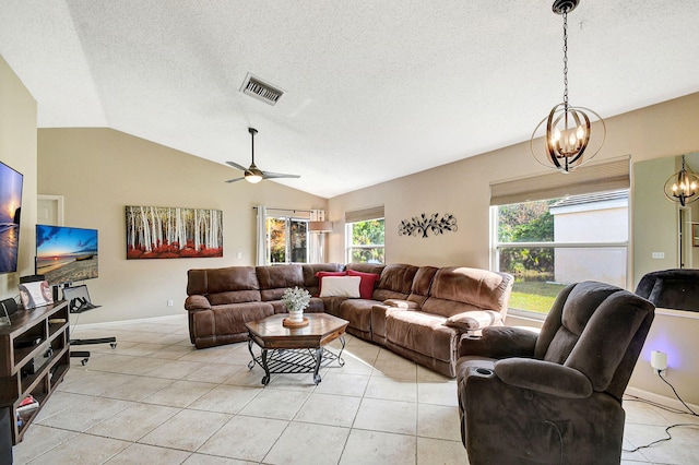 living room with ceiling fan with notable chandelier, lofted ceiling, light tile patterned floors, and a textured ceiling