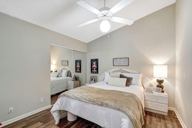 bedroom featuring vaulted ceiling, dark wood-type flooring, ceiling fan, and a closet