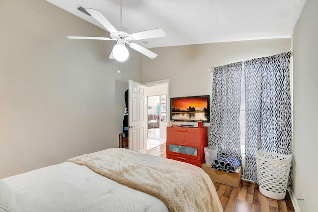 bedroom with hardwood / wood-style flooring, ceiling fan, and lofted ceiling