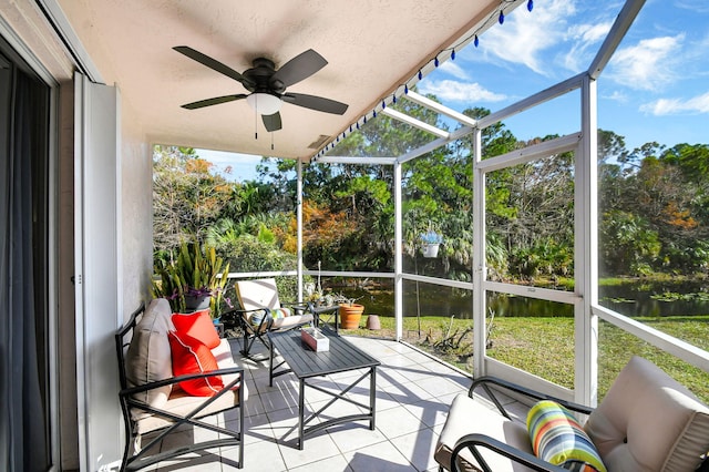 sunroom / solarium featuring a water view and ceiling fan