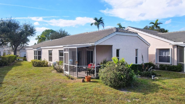 rear view of property featuring a patio, a sunroom, and a lawn