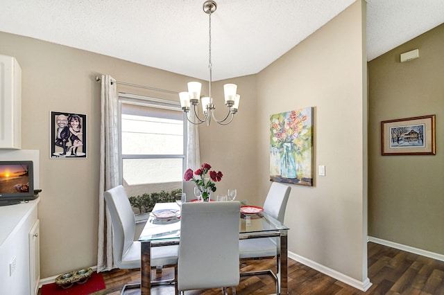 dining space with a notable chandelier, dark wood-type flooring, and a textured ceiling