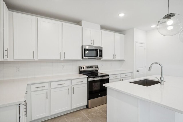 kitchen featuring light tile patterned floors, a sink, white cabinets, appliances with stainless steel finishes, and tasteful backsplash