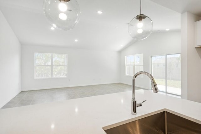 kitchen with pendant lighting, a sink, recessed lighting, light countertops, and lofted ceiling