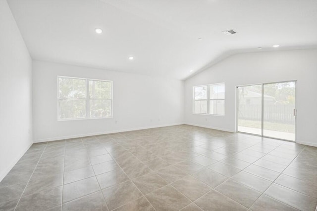 spare room with lofted ceiling, baseboards, visible vents, and tile patterned floors