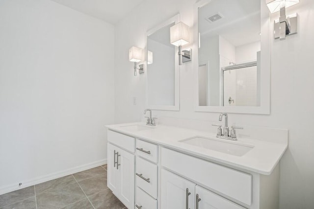 full bath with tile patterned floors, double vanity, a stall shower, and a sink