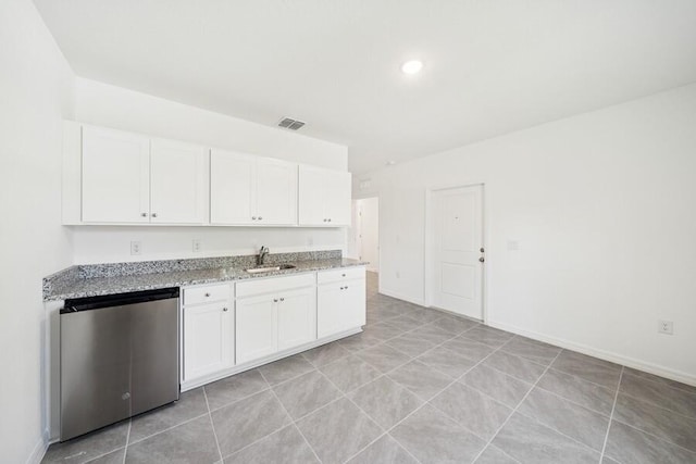 kitchen featuring visible vents, light stone counters, stainless steel dishwasher, white cabinetry, and a sink