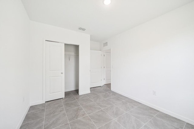 unfurnished bedroom with a closet, baseboards, and visible vents