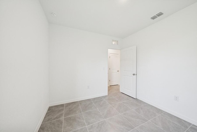 spare room featuring baseboards and visible vents