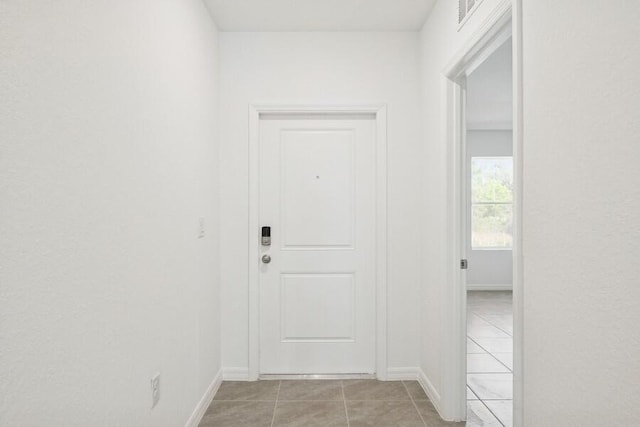 interior space featuring light tile patterned floors, baseboards, and visible vents