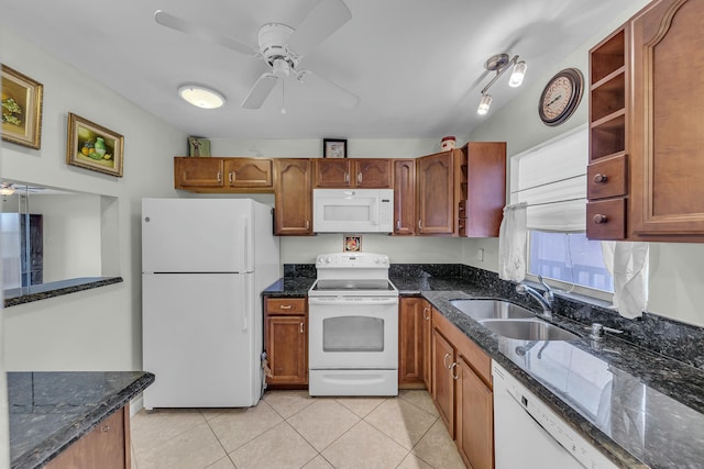 kitchen with sink, dark stone counters, light tile patterned floors, ceiling fan, and white appliances