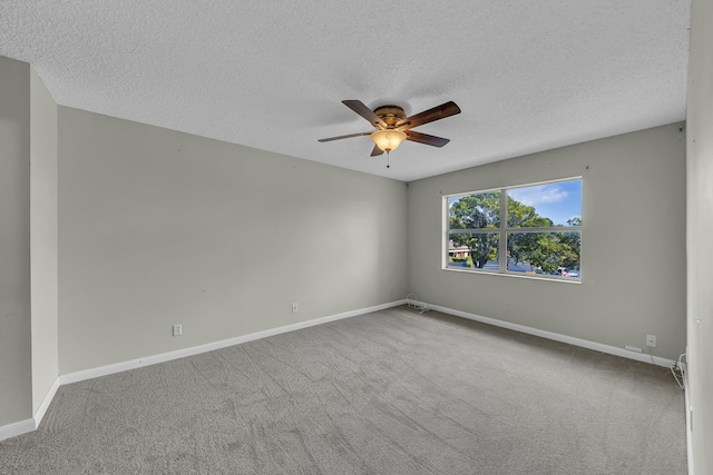 carpeted empty room with ceiling fan and a textured ceiling