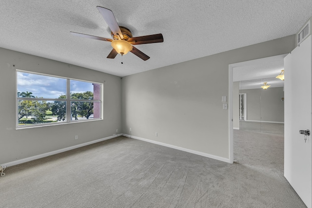 carpeted empty room with ceiling fan and a textured ceiling