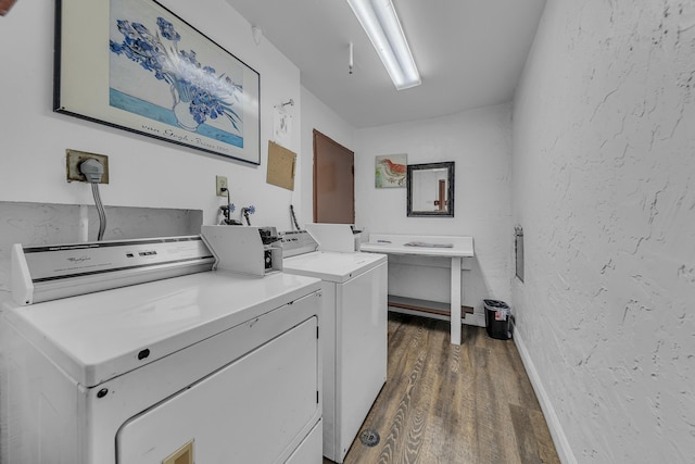 laundry room with dark wood-type flooring and washer and dryer