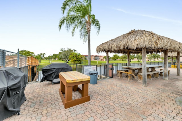 view of patio with a gazebo, a water view, and area for grilling