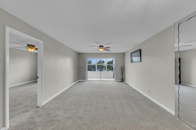 carpeted empty room featuring ceiling fan and a textured ceiling