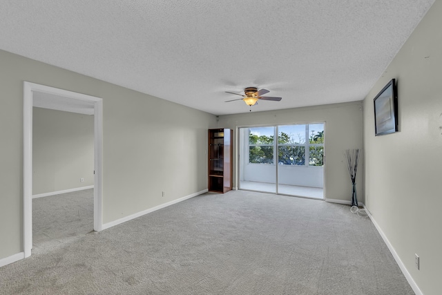 carpeted spare room with ceiling fan and a textured ceiling