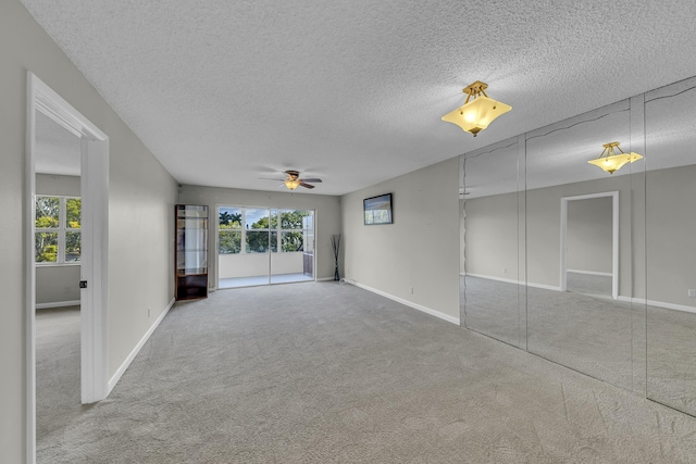 unfurnished room featuring ceiling fan, carpet flooring, and a textured ceiling