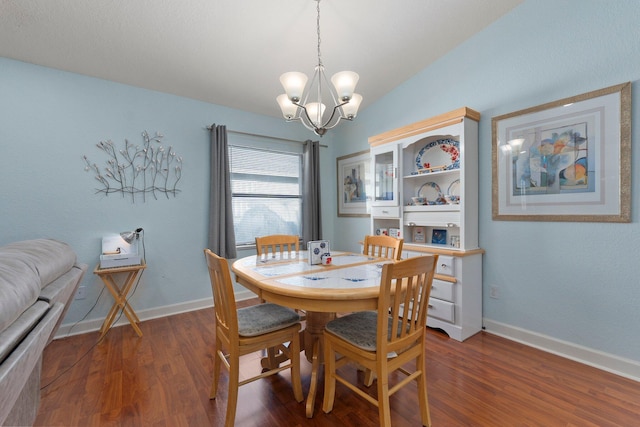 dining area with lofted ceiling, dark hardwood / wood-style floors, and an inviting chandelier