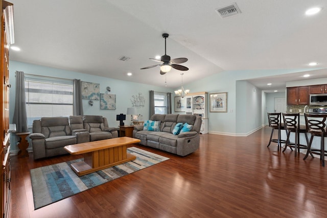 living room with vaulted ceiling, dark hardwood / wood-style floors, and ceiling fan with notable chandelier