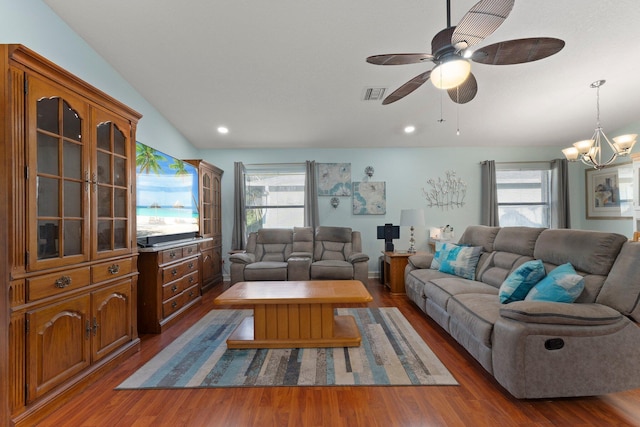 living room with ceiling fan with notable chandelier, wood-type flooring, a healthy amount of sunlight, and vaulted ceiling