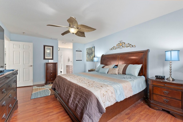 bedroom featuring ceiling fan, wood-type flooring, and ensuite bath