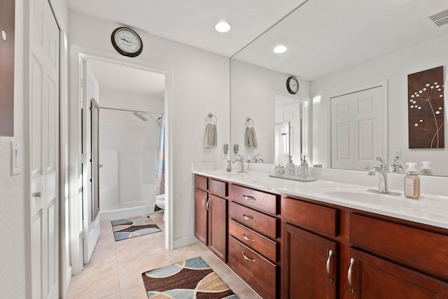 bathroom featuring vanity, toilet, tile patterned flooring, and a shower