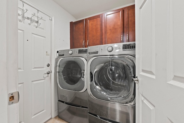 washroom featuring cabinets, light tile patterned flooring, and washer and dryer