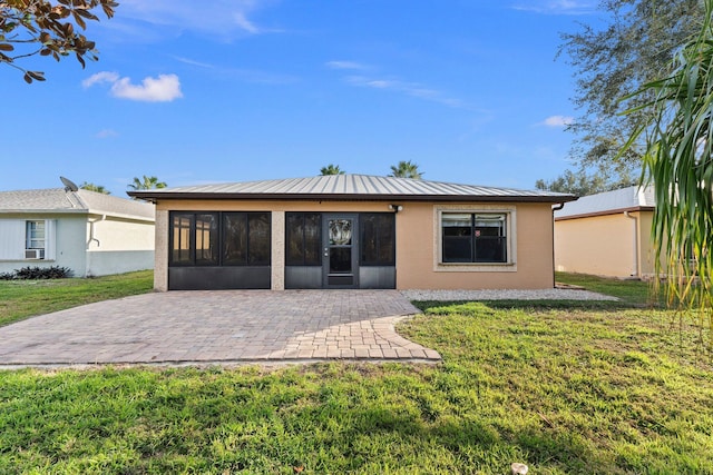 rear view of house featuring a patio, a sunroom, and a yard