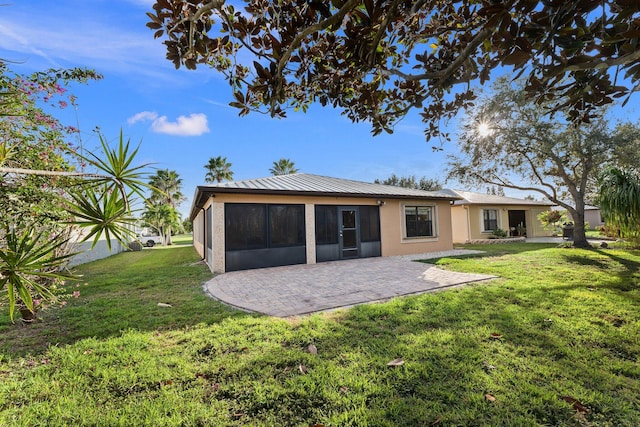 back of property featuring a sunroom, a yard, and a patio area