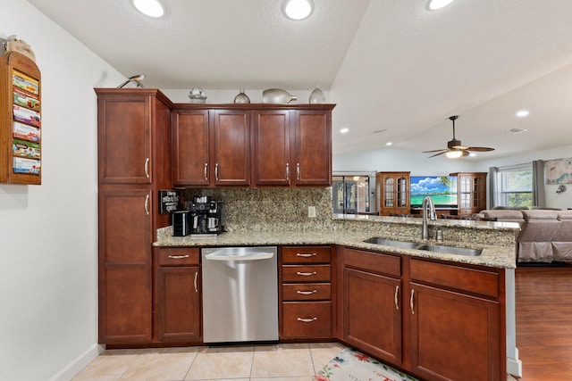 kitchen with lofted ceiling, sink, stainless steel dishwasher, and kitchen peninsula