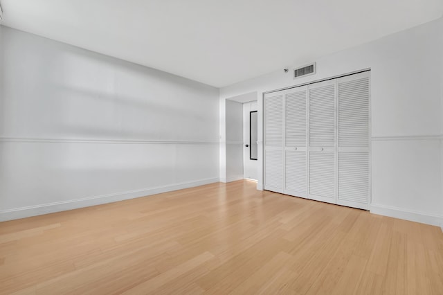 unfurnished bedroom with light hardwood / wood-style floors and a closet