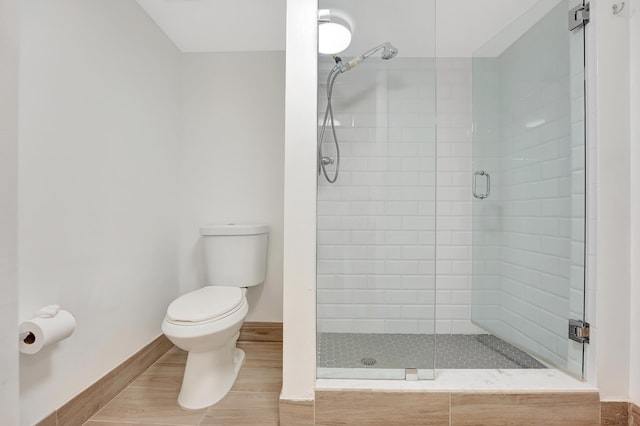 bathroom with hardwood / wood-style floors, toilet, and walk in shower