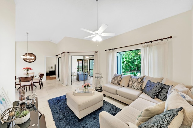 tiled living room featuring vaulted ceiling and ceiling fan with notable chandelier