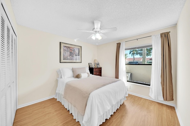 bedroom featuring wood-type flooring, ceiling fan, a textured ceiling, and a closet