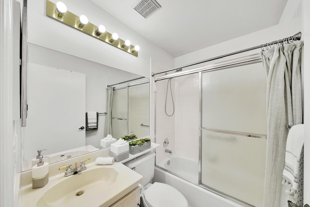 full bathroom with bath / shower combo with glass door, vanity, and toilet