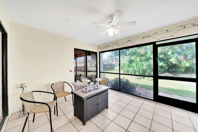 sunroom featuring ceiling fan