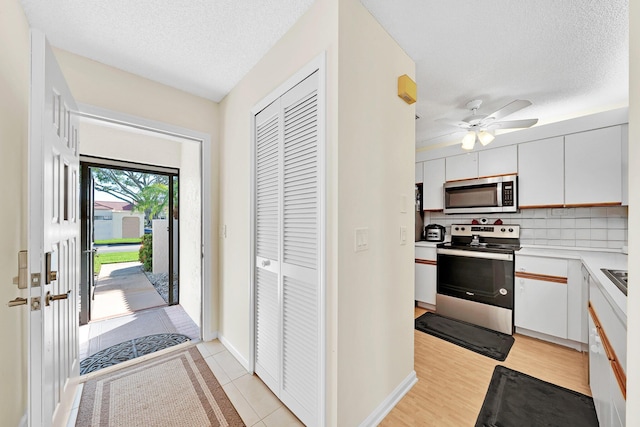 entrance foyer featuring ceiling fan, a textured ceiling, and light hardwood / wood-style flooring