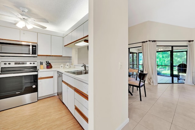 kitchen featuring sink, white cabinetry, backsplash, stainless steel appliances, and a textured ceiling