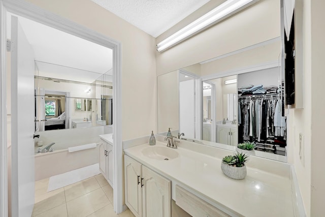 bathroom with tile patterned flooring, vanity, and a textured ceiling