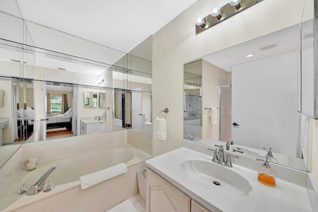 bathroom with vanity and shower with separate bathtub