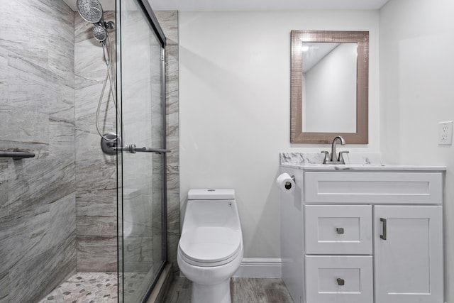 bathroom with a shower with door, vanity, hardwood / wood-style floors, and toilet