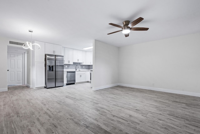 unfurnished living room featuring ceiling fan, sink, and light hardwood / wood-style floors