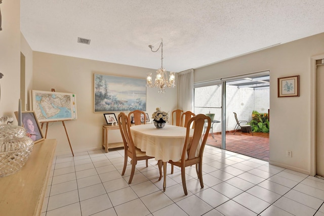 dining area featuring light tile patterned flooring, a textured ceiling, and a notable chandelier