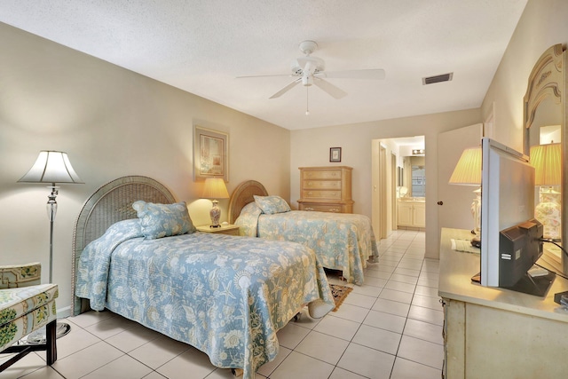 bedroom with ceiling fan, ensuite bathroom, a textured ceiling, and light tile patterned floors